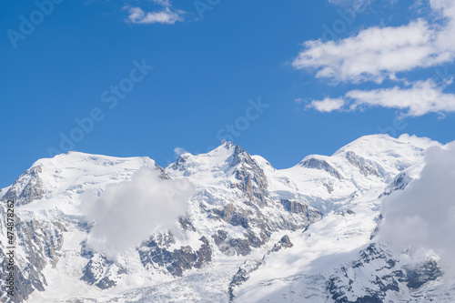 Clouds over Mont Blanc du Tacul, Mont Maudit and Mont Blanc in Europe, France, the Alps, towards Chamonix, in summer, on a sunny day.