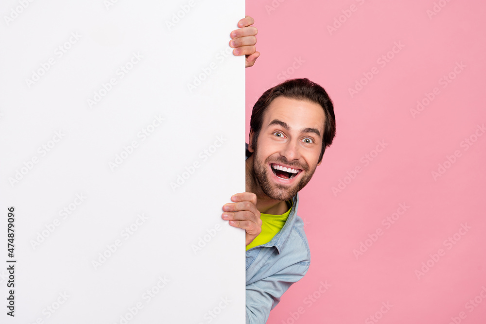 Photo of young cheerful guy good mood hold big white banner advertise isolated over pink color background Photo of young cheerful guy good mood hold big white banner advertise isolated over pink color background