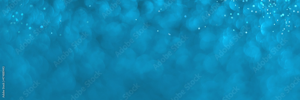 Blue sparkling glitter bokeh background, christmas texture. Holiday lights. Abstract defocused header. Wide screen wallpaper. Panoramic web banner with copy space for design