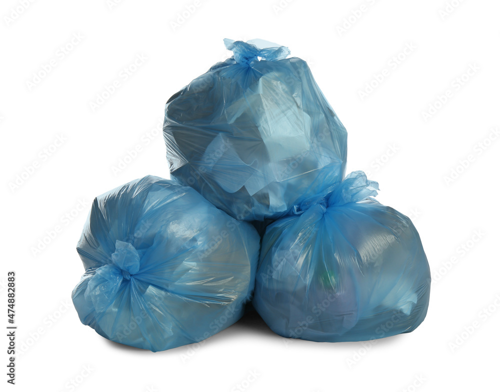 Blue trash bags filled with garbage on white background