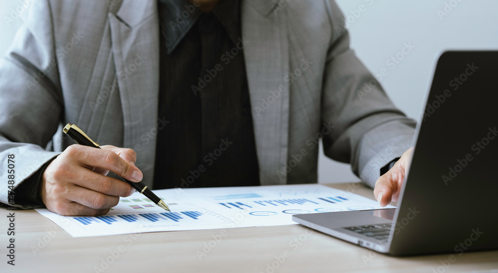 Close up of businessman or accountant hand holding pen using calculator to calculate numbers with business chart data. Accountancy documents and business information on the desk at the office, Close up of businessman or accountant hand holding pen using calculator to calculate numbers with business chart data. Accountancy documents and business information on the desk at the office,