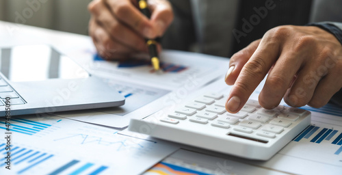 Business accounting concept, Business man using calculator with computer laptop, budget and loan paper in office.