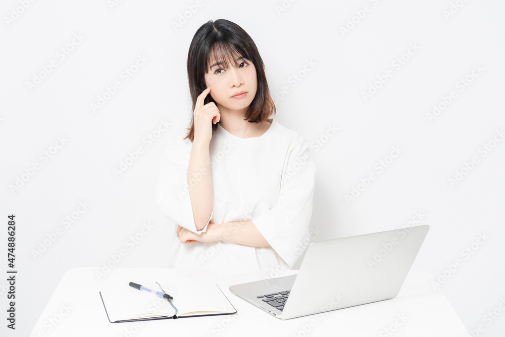 パソコンを使いながら悩んでいる若い女性 パソコンを使いながら悩んでいる若い女性
