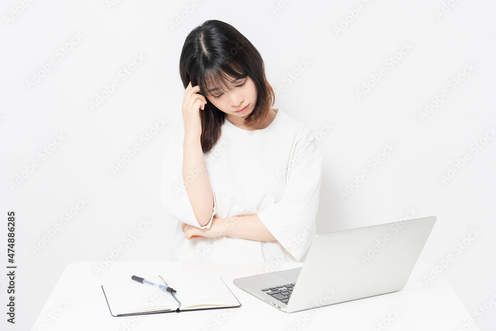 パソコンを使いながら悩んでいる若い女性 パソコンを使いながら悩んでいる若い女性