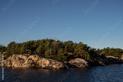 Landscape of trees on rocky islands in Lusefjord. Fjord cruise. Tourism in Norway. Beautiful nature on sunny day.