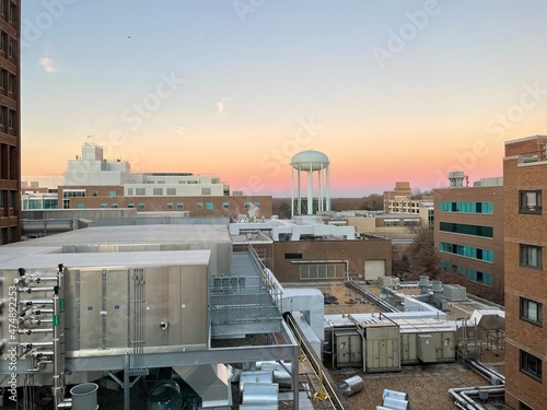 Falls Church, Virginia, USA - December 14, 2021: Interior buildings of INOVA Fairfax Hospital as seen at sunrise from a patient’s room featuring the water tower