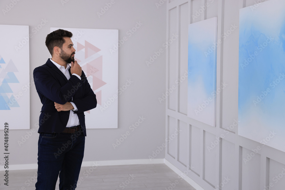 Thoughtful young man at exhibition in art gallery