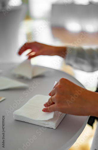 Female Waiters Hand Folding Paper Napkins In Restaurant