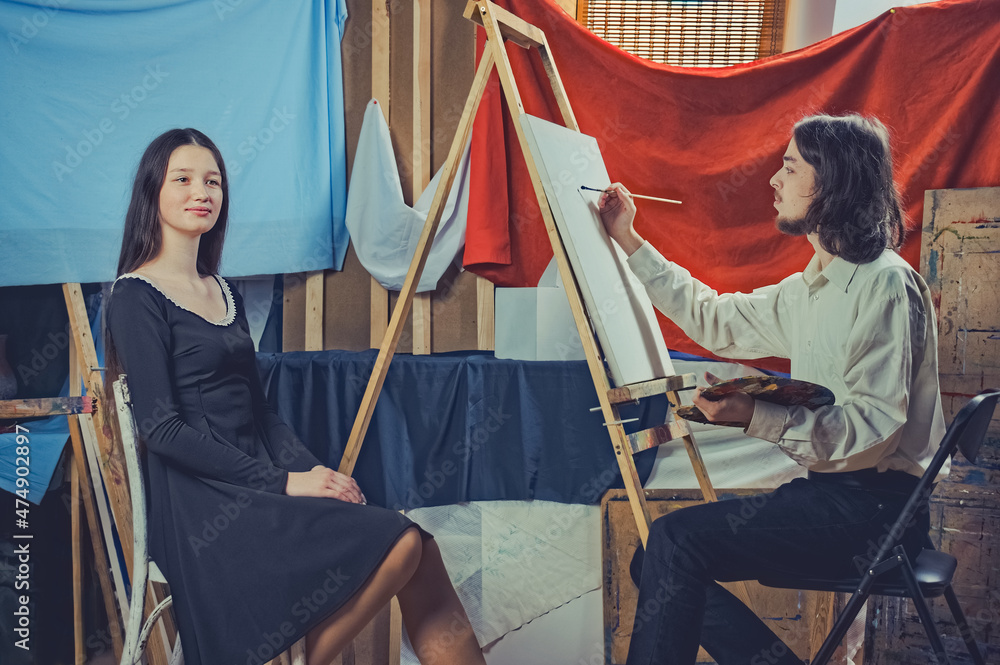 young artist paints a portrait of a beautiful girl young artist paints a portrait of a beautiful girl