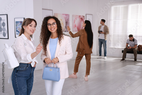 Fényképezés Young women at exhibition in art gallery
