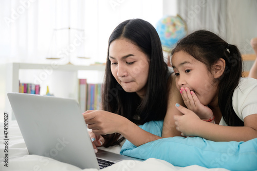 child girl person 2 sisters watching media and learning on laptop, online communication at home © chokniti