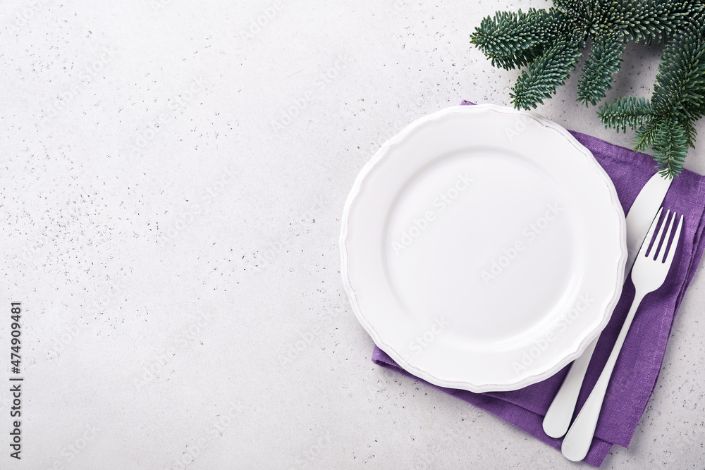 Christmas table setting white color with silverware, napkin trendy color very peri in 2022 Year, Christmas balls, stars, champagne, glasses on white background for xmas greetings. Mock up. Christmas table setting white color with silverware, napkin trendy color very peri in 2022 Year, Christmas balls, stars, champagne, glasses on white background for xmas greetings. Mock up.