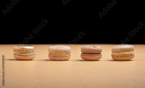 Golden luxury dessert cake macaron on pastel background. Festive desserts. Top view.