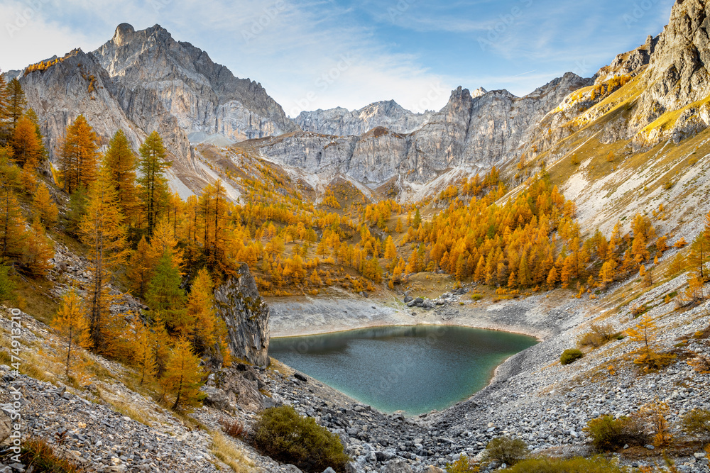 Lago Visaisa incastonato nei larici d'autunno