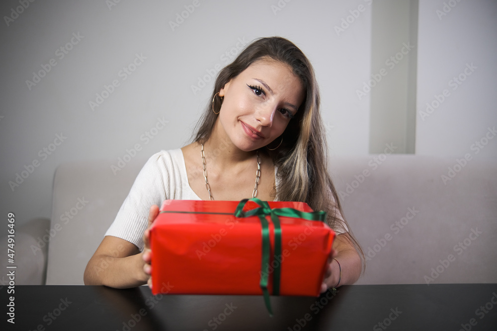 smiling woman holding red wrapped gift wrap , indoor photo smiling woman holding red wrapped gift wrap , indoor photo