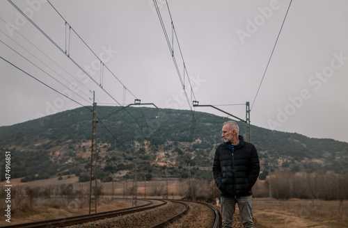 Adult man in warm clothing with railway in countryside. Shot in Castilla la Mancha, Spain