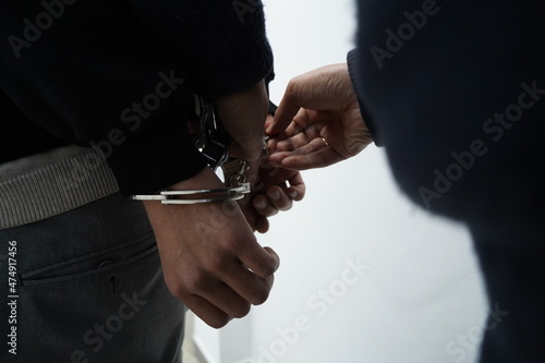 A police officer handcuffs a suspect