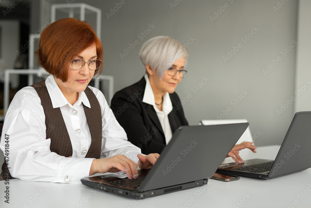 two stylish businesswoman in black suits at the workplace two stylish businesswoman in black suits at the workplace