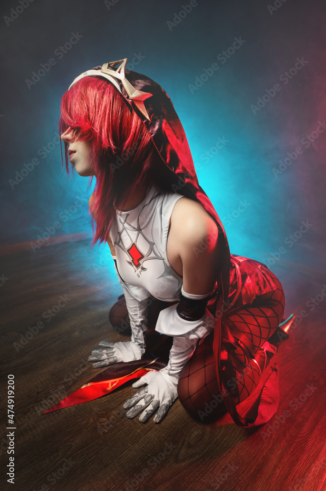 Cosplay. Studio portrait of attractive sexy young woman in anime rosary  costume with red hairs and white gloves. Sexual pose on the floor in  colored light Stock Photo | Adobe Stock