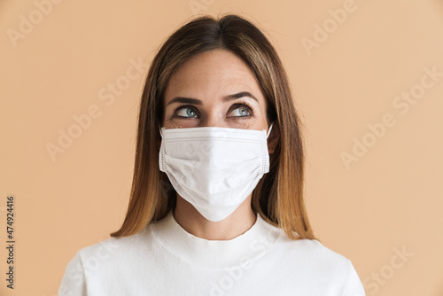 White mid woman looking at camera while posing in face mask © Drobot Dean