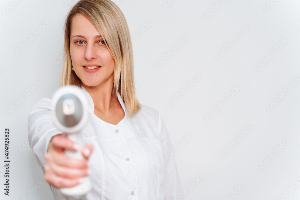 Portrait of master of laser hair removal. Woman in white coat hold laser hair removal device in her hands and show as shoot from it Portrait of master of laser hair removal. Woman in white coat hold laser hair removal device in her hands and show as shoot from it