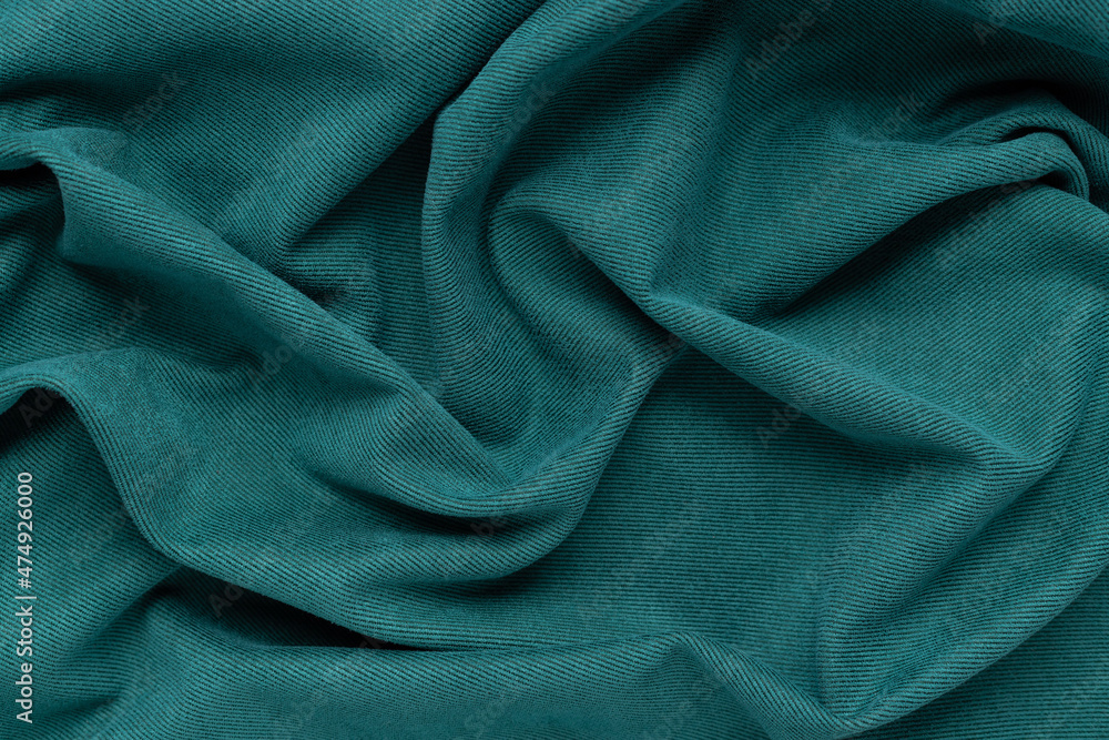 green fabric background with folds. Wavy folds material. Textile and texture concept green fabric background with folds. Wavy folds material. Textile and texture concept