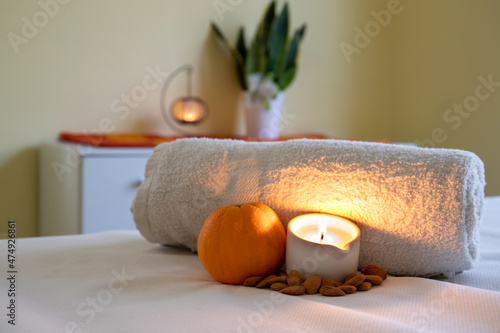 Towel with candle and warm lamp. Massage with oil and candles. Massage therapy for one person by candlelight. Beauty spa treatment and relaxation concept.