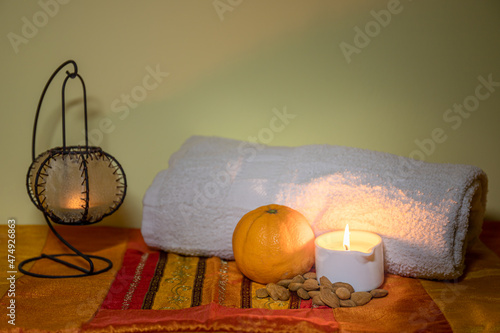 Towel with candle and warm lamp. Massage with oil and candles. Massage therapy for one person by candlelight. Beauty spa treatment and relaxation concept.