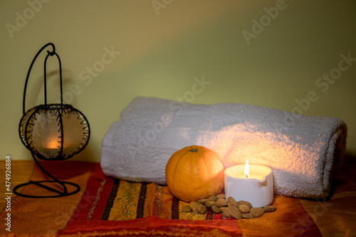 Towel with candle and warm lamp. Massage with oil and candles. Massage therapy for one person by candlelight. Beauty spa treatment and relaxation concept.