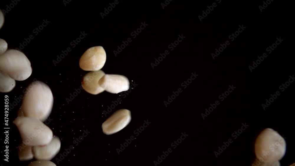 Nuts. Raw blanched peanuts fall on a black mirror surface. Slow motion. Nuts. Raw blanched peanuts fall on a black mirror surface. Slow motion.