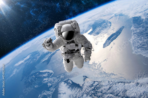 Fototapeta Naklejka Na Ścianę i Meble -  Astronaut in outer open space over the planet Earth.Stars provide the background.erforming a space above planet Earth.Sunrise,sunset.Our home. ISS.Elements of this Image Furnished by NASA.