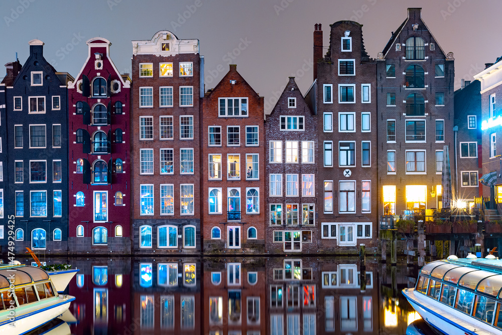 Dancing houses at Amsterdam canal Damrak at night, Holland, Netherlands
