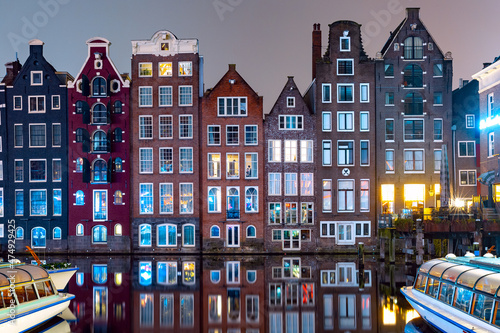 Canvas Print Dancing houses at Amsterdam canal Damrak at night, Holland, Netherlands