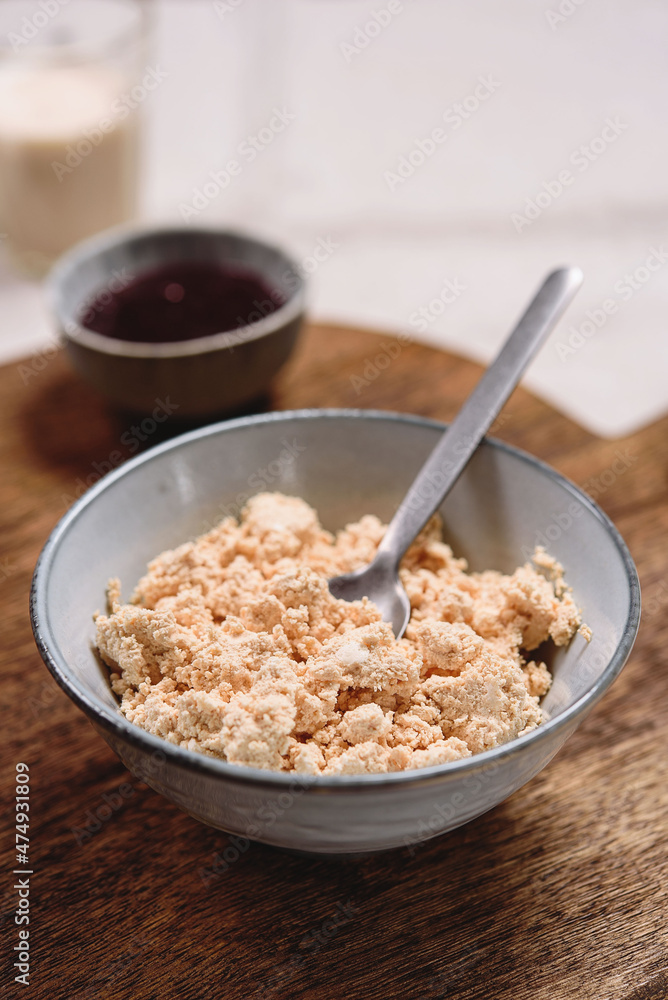 Homemade melted cheese curd served with baked milk and jam on wooden cutboard. Healthy breakfast. Haze effect. Selective focus Homemade melted cheese curd served with baked milk and jam on wooden cutboard. Healthy breakfast. Haze effect. Selective focus
