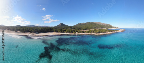 Panoramic photo of Cala Agulla beach in Mallorca. Beautiful view of the seacoast of Mallorca with an amazing turquoise sea, in the middle of the nature. Concept of summer, travel, relax and enjoy.