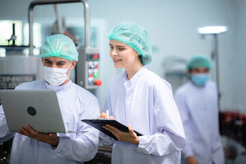 food technician control checking production line of water drink in manufacturing factory