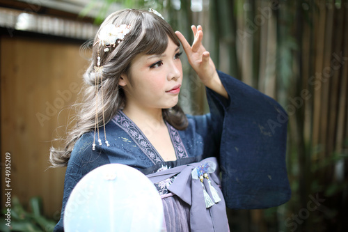 Canvas Print Beautiful young woman with dark blue Chinese lolita dress with Chinese garden