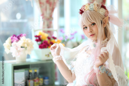 Tableau sur toile Beautiful young woman with white lolita dress with flowers garden Japanese fashi