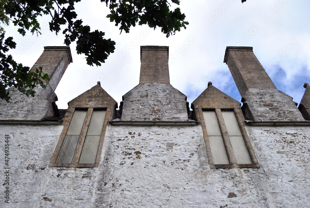 Three Chimneys & Two Windows on Stone Wall of Old House seen from Below Three Chimneys & Two Windows on Stone Wall of Old House seen from Below