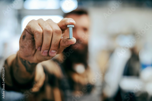 Fotografie Close up of worker holding screw