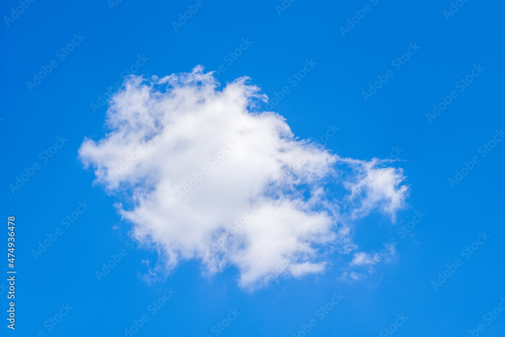 A cumulus cloud flake on a blue sky background in Europe, France, in summer, on a sunny day.