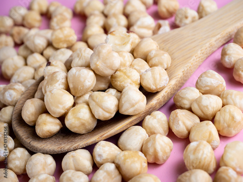 Some hazelnuts on a wooden spoon.