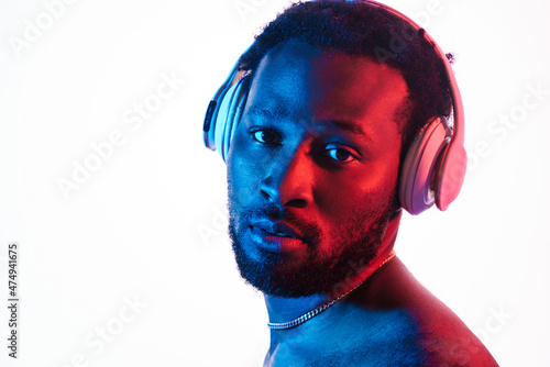 Young black man in shirt listening music with headphones
