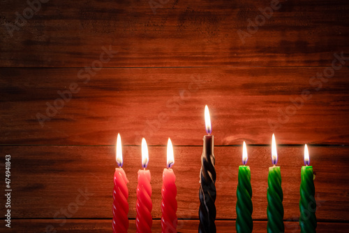 Happy Kwanzaa. African American holiday. Seven burning candles, red, black and green, in kinara candlestick. photo