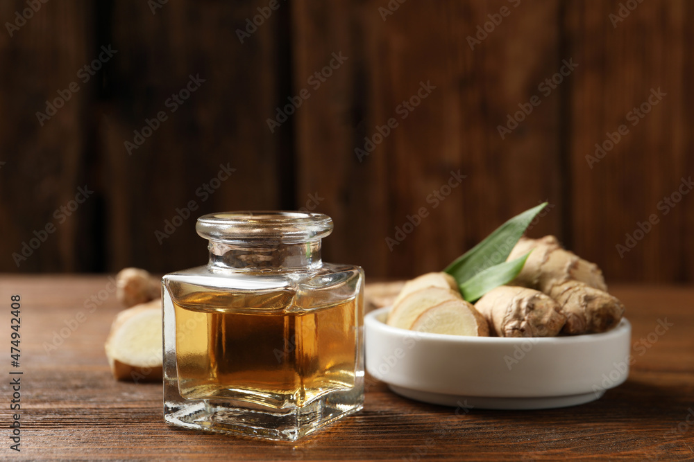 Ginger essential oil in bottle on wooden table