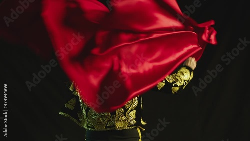 Male dancer or toreador imitating moves of matador bullfighter on black smoky background .  Man bullfighter dressed in bullfighting costume . Shot on ARRI Alexa cinema camera in Slow Motion  photo