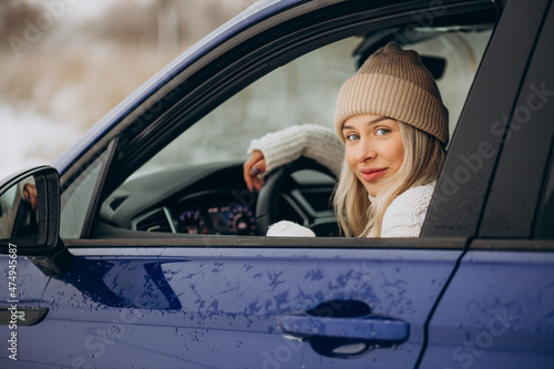 Woman sitting in her new car in a winter park