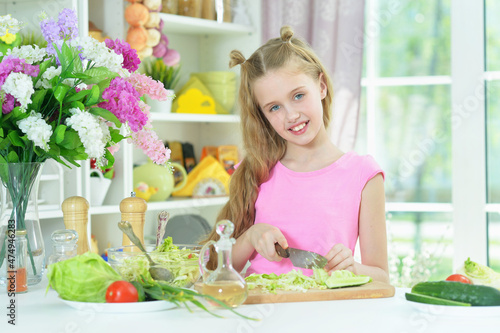 Cute girl preparing delicious fresh salad