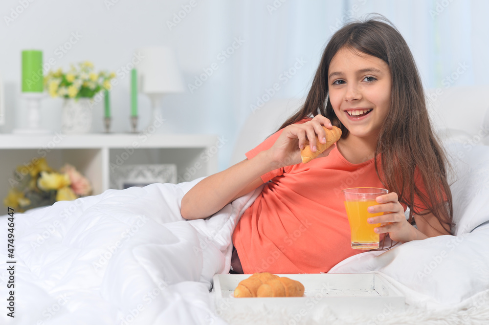 Cute girl with breakfast  at home on bed