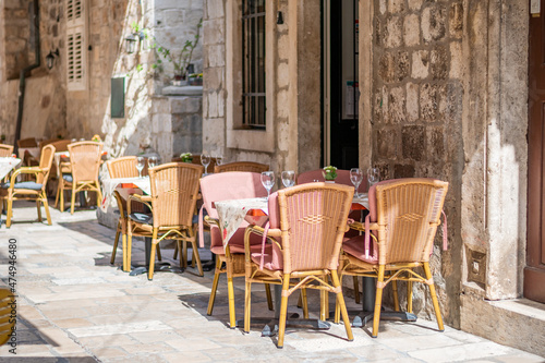 Table and chairs at the restaurant in narrow street are prepared for guests and tourist. Old city of Dubrovnik, Croatia.